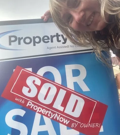 Selfie of a woman with her sold sign